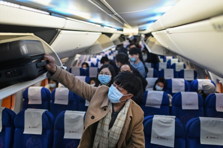 Passengers wearing protective facemasks as a preventive measure against  Covid-19 leave a plane upon their arrival at the Tianhe International Airport in Wuhan, China