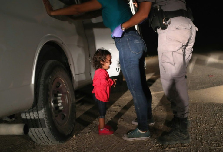 A two-year-old girl from Honduras cries as US border patrol agents search and detain her mother near the US-Mexico border on June 12, 2018 in McAllen, Texas