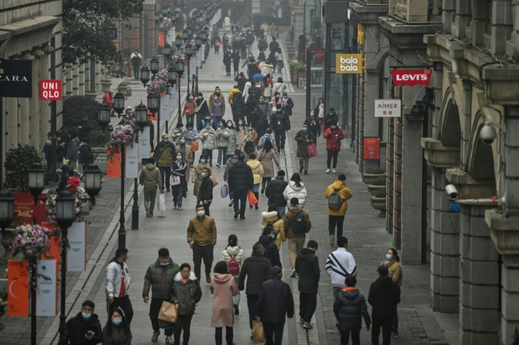 People walk along a pedestrian street in Wuhan, one year after the city went into lockdown to curb the spread of the Covid-19 coronavirus