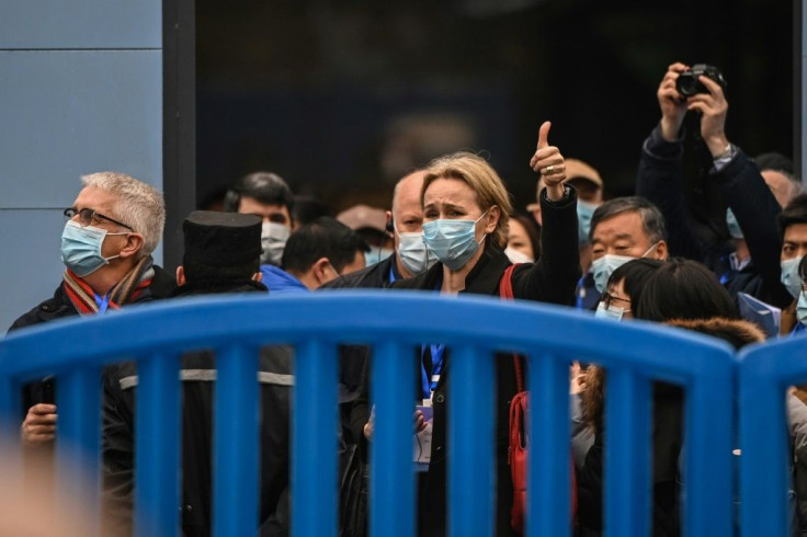 Thea Fisher (C) and other members of a WHO team investigating the origins of Covid-19 leave the Huanan Seafood wholesale market on Sunday