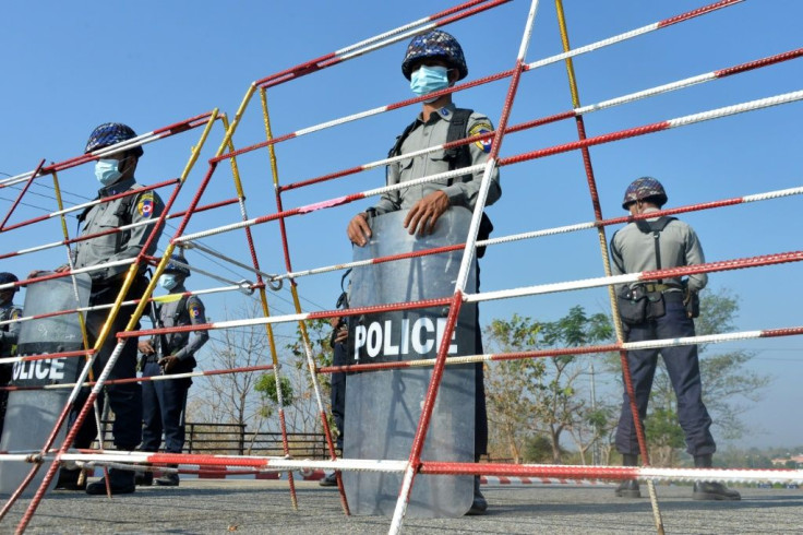 Police stand guard along a road in Naypyidaw ahead of the reopening of parliament on February 1 following the November 2020 elections which Aung San Suu Kyi's ruling National League for Democracy won in a landslide