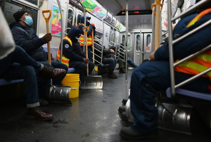 Workers hold snow shovels on the subway during a winter storm on February 1, 2021 in New York City