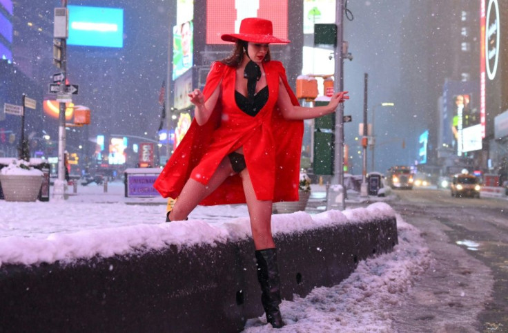 A woman climbs over a snow-covered wall in Time Square during a winter storm on February 1, 2021 in New York City