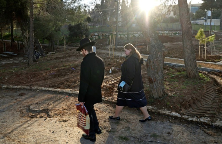 An ultra-Orthodox man and woman walk in a public park in Jerusalem; meetings between potential spouses must offer enough privacy for a personal conversation but be fully in public view