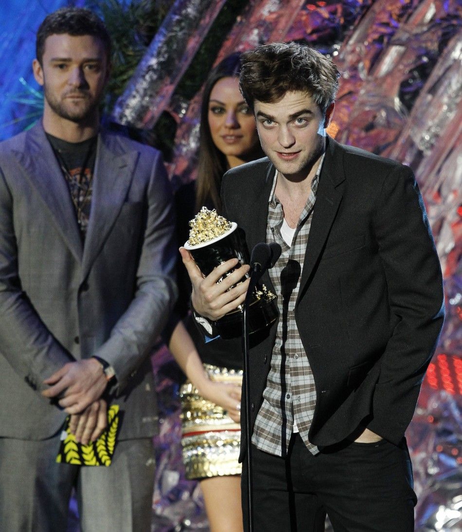 Actor Robert Pattinson accepts the award as presenters Justin Timberlake and Mila Kunis look on