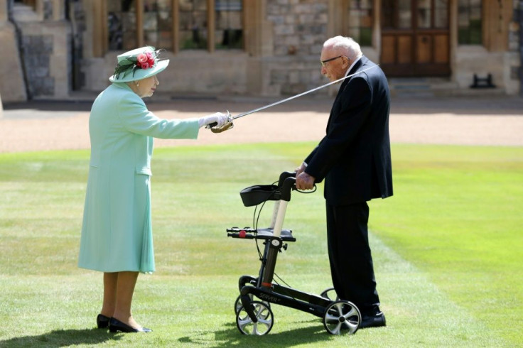 Britain's Queen Elizabeth II uses the sword that belonged to her father, George VI as she confers the Honour of Knighthood on 100-year-old veteran Captain Tom Moore at Windsor Castle in July 2020