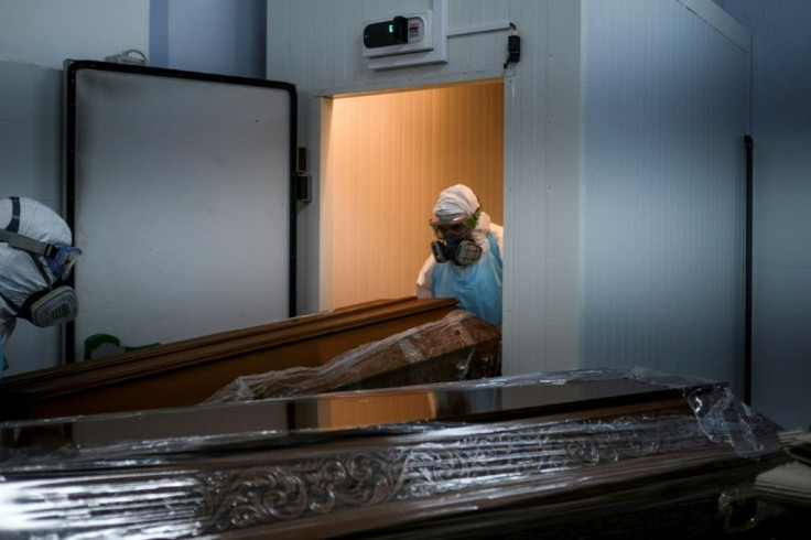 Workers place the sealed casket of a Covid victim in the crowded refrigeration room at a funeral parlour in Amadora, on the outskirts of Lisbon