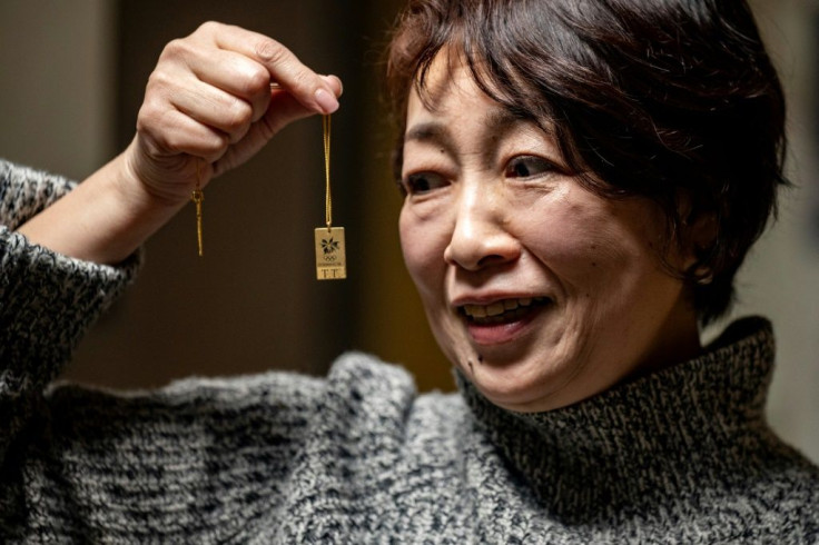 Olympic ticket-holder Yoshiko Tanaka holds a souvenir from the 1998 Nagano Winter Olympics