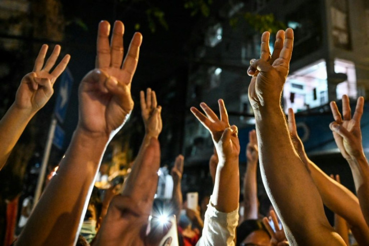 People give a three-finger salute after calls for protest went out on social media in Yangon