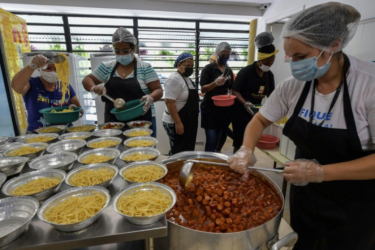 Workers prepare meals at a soup kitchen in Paraisopolis favela, where traditional loans are a nearly impossible dream for households and businesses
