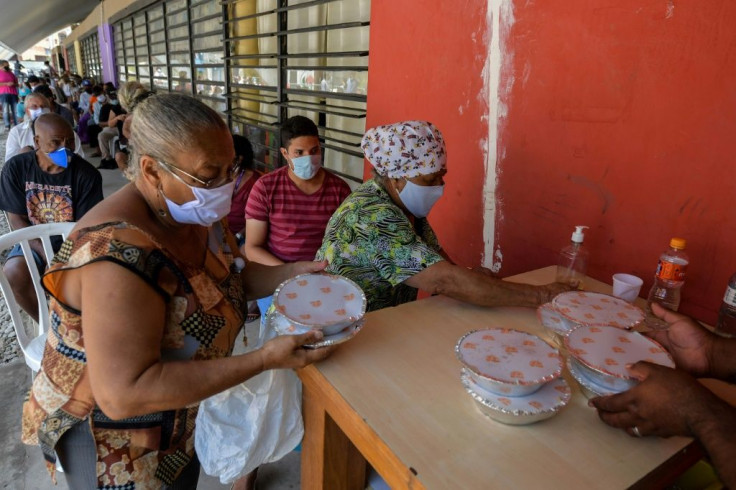 Residents receive meals at a soup kitchen of Paraisopolis, the second-biggest favela in Sao Paulo, with more than 100,000 residents