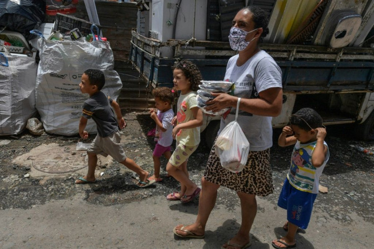 Celia da Costa Gomes, resident of Paraisopolis favela, walks home with her children after receiving a meal, in Sao Paulo, Brazil, on January 28, 2021