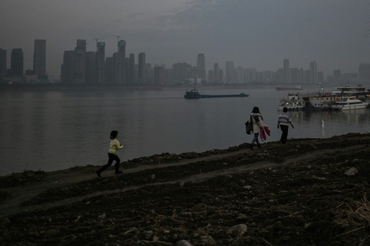 People walk in a park next to the Yangtze river in Wuhan on Wednesday