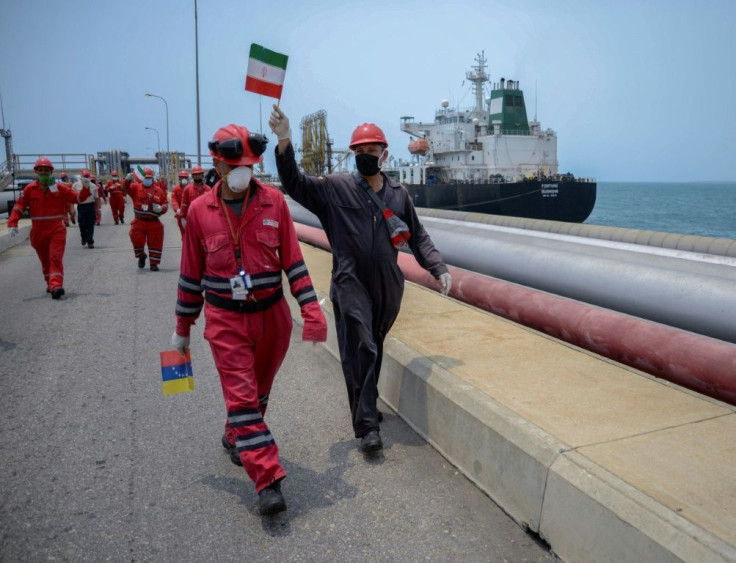 A worker of the Venezuelan state oil company PDVSA waves an Iranian flag as the Iranian-flagged oil tanker Fortune docks at the El Palito refinery in Puerto Cabello, in the northern state of Carabobo, Venezuela, on May 25, 2020