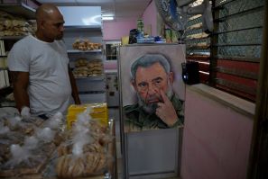 A man looks at a painting of late Cuban leader Fidel Castro at a bakery in Havana on January 26, 2021