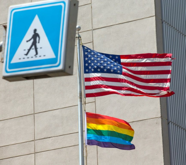 A gay pride flag is raised next to the US flag at the US embassy in Israel during a June 2014 Pride parade in Tel Aviv