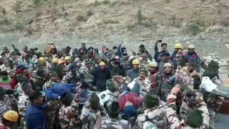 Emergency workers pull out more trapped men from a tunnel after a flood triggered by a piece of Himalayan glacier breaking off in northern India