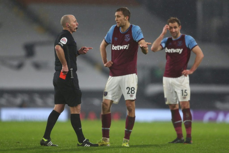Referee Mike Dean shows West Ham's Tomas Soucek a red card