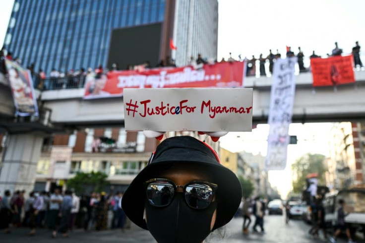 A protester wears a sign with a hashtag #justiceformyanmar as they take part in a demonstration against the military coup in Yangon on February 8
