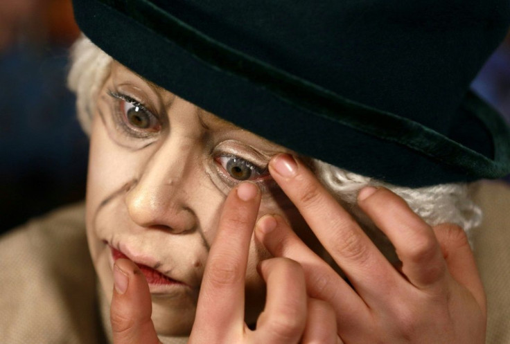Make-up artist Alaa Bliha applies coloured eye lenses to complete her imitation make-up to resemble Queen Elizabeth II