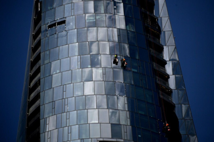 Workers clean glass panels of the under construction Crown Sydney casino building in Sydney on November 20, 2020.