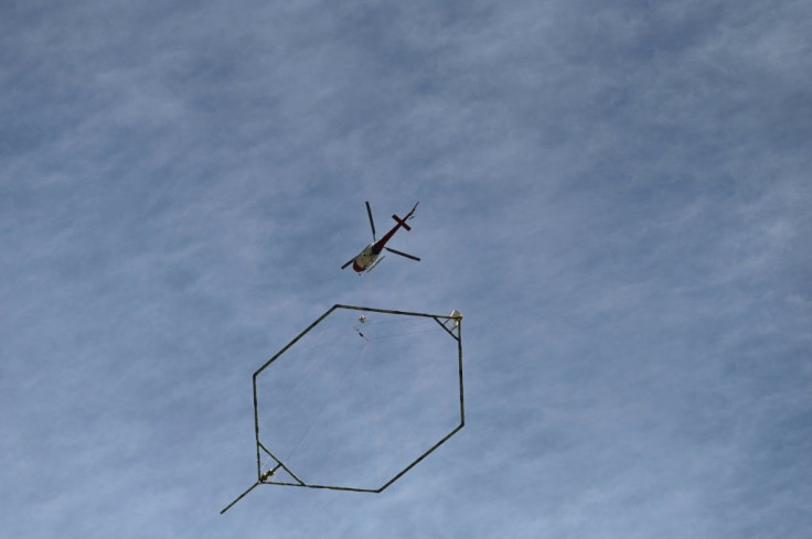A helicopter equipped with a surface penetrating high definition camera hovers over the Tapovan tunnel, where workers are trapped