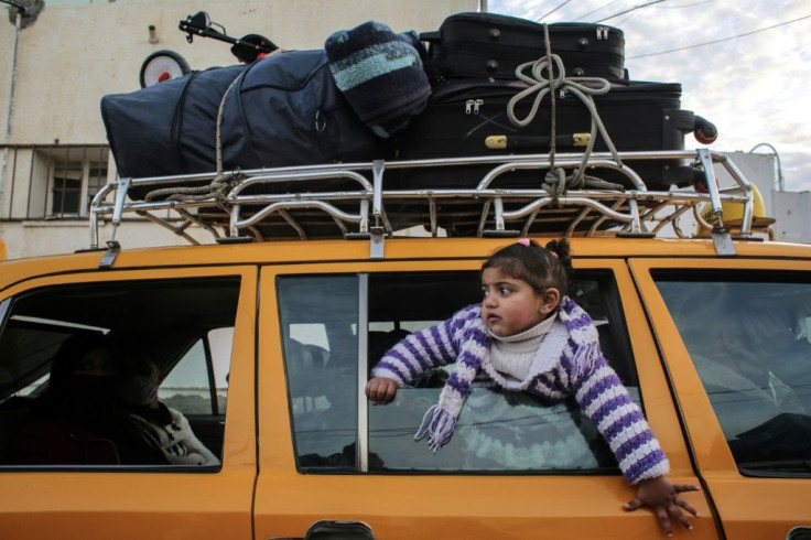 A girl pokes her head through the window of a loaded vehicle at the Rafah border crossing between Gaza and Egypt