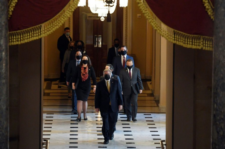 The House Sergeant of Arms (front) walks with House impeachment managers to the Senate floor as they arrive for the start of the trial of former US president Donald Trump