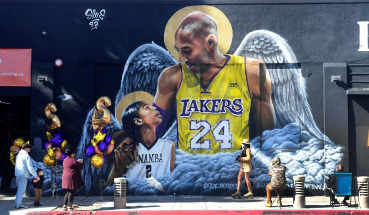 People gather in front of a mural of former Los Angeles Laker Kobe Bryant and his daughter Gianna by artist sloe_motions downtown Los Angeles