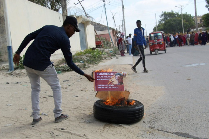 A man burns a poster of Somali President Mohamed Abdullahi Mohamed in Mogadishu in December 2020 amid a political impasse