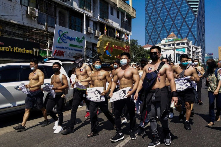 The shirtless men held signs calling for the release of detained civilian leader Aung San Suu Kyi