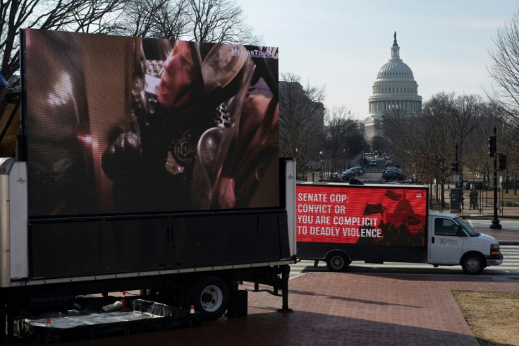 Before the second day of Donald Trump's Senate trial, a screen shows images of a police officer trapped by a pro-Trump mob at the US Capitol