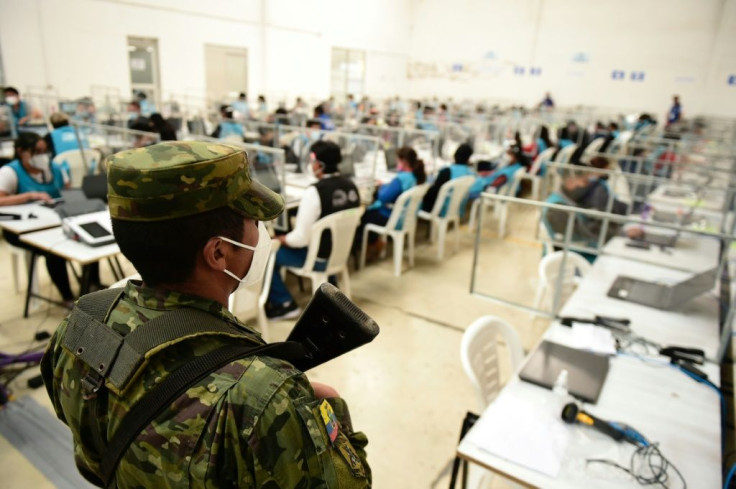 A soldier stands guard as National Electoral Council workers count votes