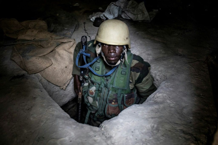 A Senegalese soldier emerges from a bunker at a captured rebel base in Blaze Forest in Casamance