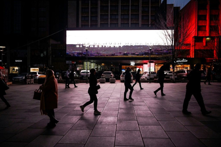 Pedestrians walk past a giant screen with election messages in downtown Pristina as Kosovo readies for its fifth snap poll since 2008