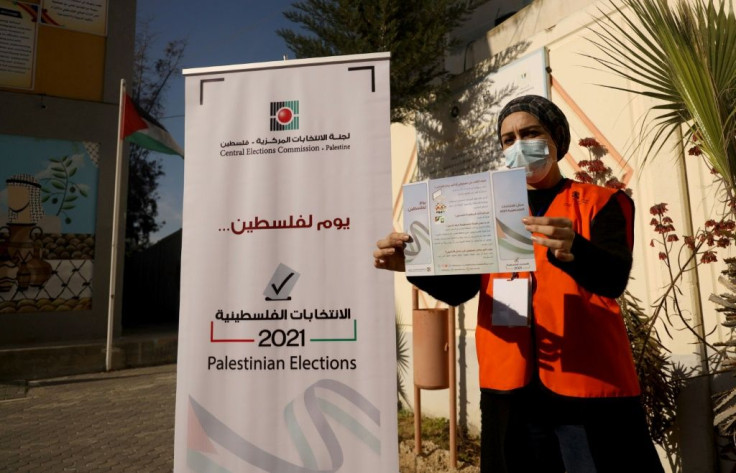 A Palestinian member of the Central Elections Commission displays an information leaflet following the opening of the first Voter Information and Registration Centre in Gaza City ahead of polls due later this year
