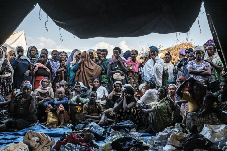 People fleeing violence in the Metekel zone gather outside a tent where clothes are being distributed at a camp in Chagni, Ethiopia