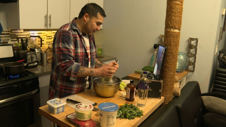 Brandon Ballin talks to his fiancee, Mari Solberg in Oslo, via video call as he cooks in his Brooklyn apartment