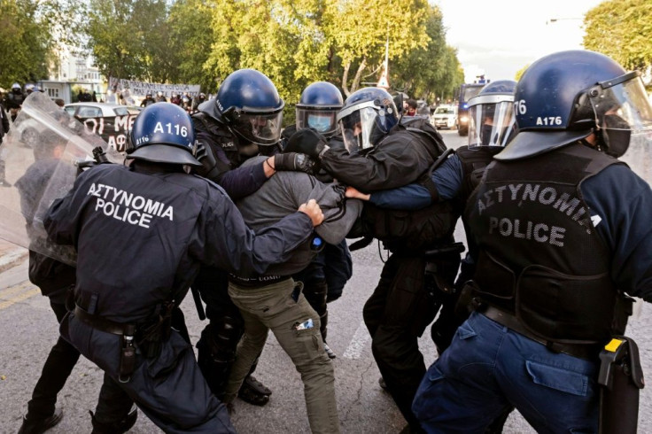 Riot police detain a demonstrator in Nicosia on Saturday
