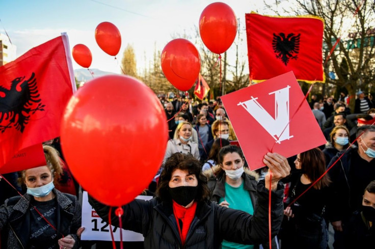 Supporters of the Vetevendosje (Selfdetermination) movement wave Albanian flags during a campaign rally in the town of Gjakova on February 7