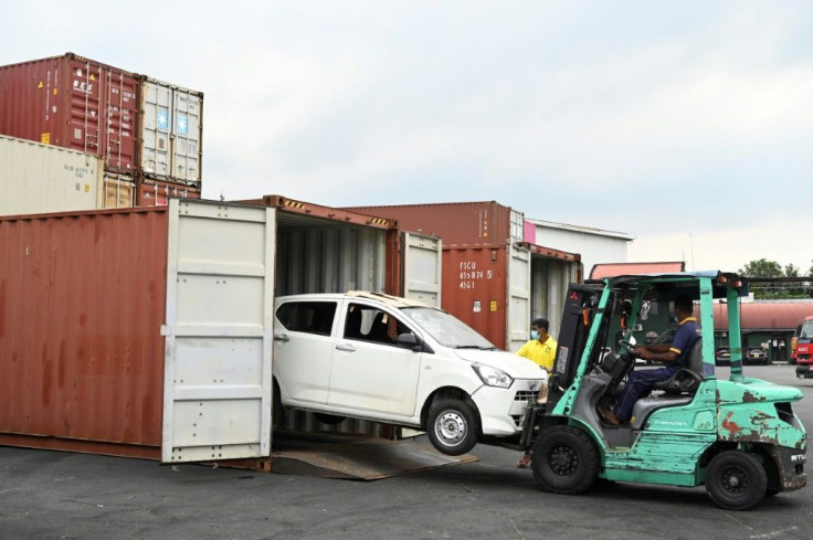 Workers unload illegally imported vehicles at a warehouse in Colombo