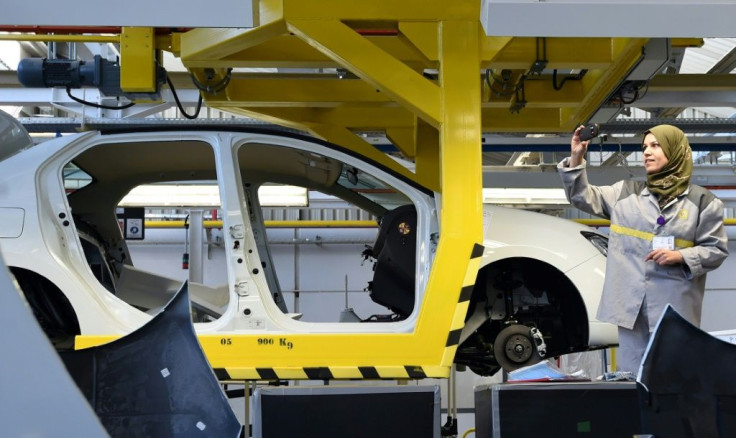 An employee of French carmaker Renault group takes a picture of a car in production at a plant, in the south of the Algerian city of Oran