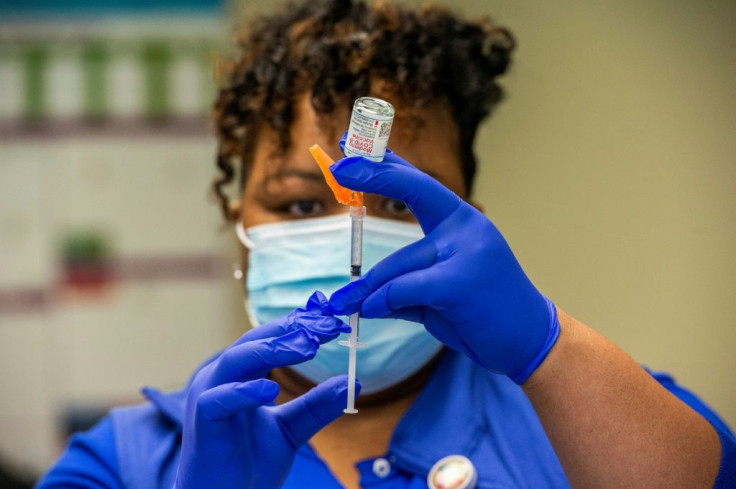 Registered nurse Natalie O'Connor loads syringes with Covid-19 shots before heading out to see patients at their homes in the United States