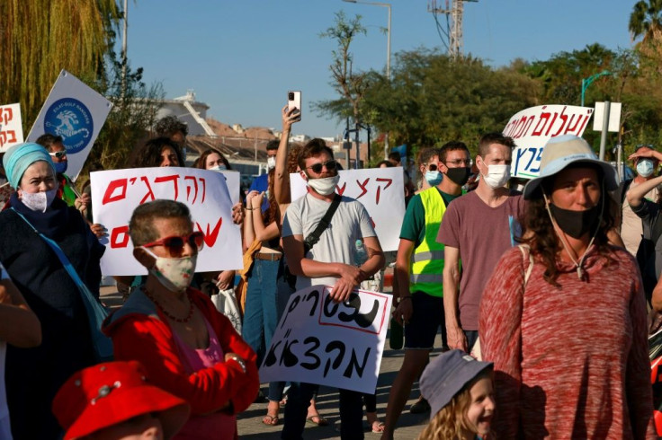 Environmental activists gather for a protest at a parking lot overlooking an oil jetty in the port city of Eilat