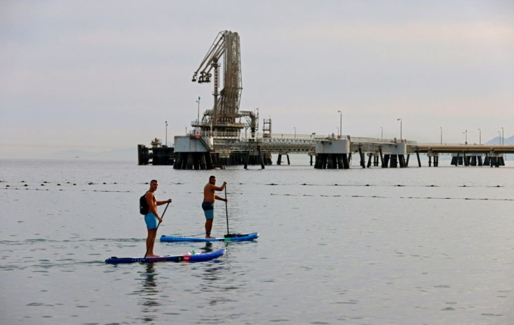 Men row on standup paddle boards in the Red Sea waters near the Eilat-Ashkelon Pipeline Company's (EAPC) oil terminal