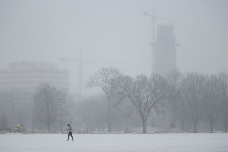 A person walks in Centennial Park as freezing rain falls in Nashville, Tennessee