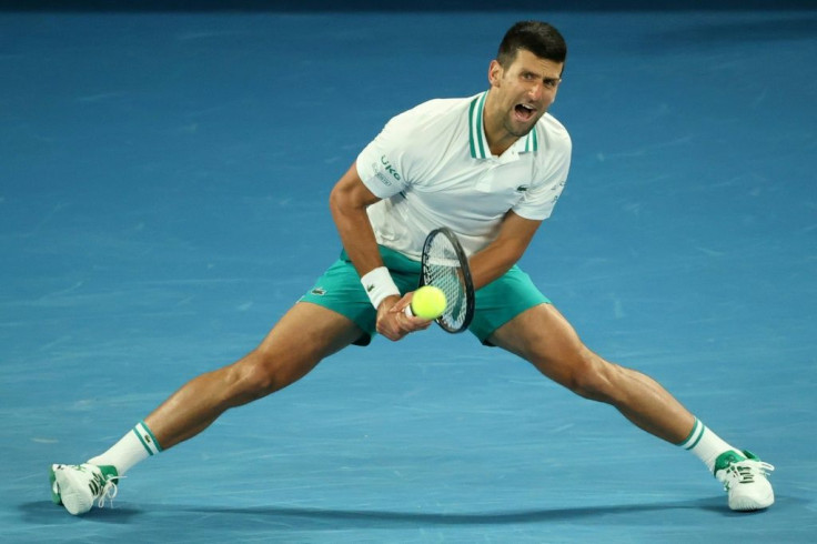 Serbia's Novak Djokovic grimaces as he stretches for a shot during his win against Milos Raonic