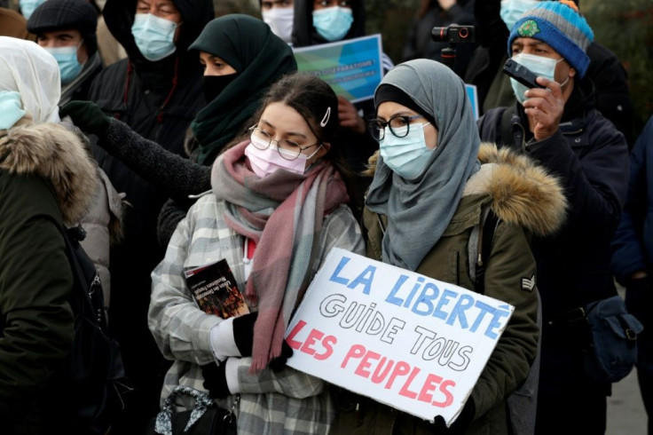 A woman holds a placard reading "Freedom guides all the people" as protesters demonstrate on February 14 against a bill to crack down on what has been termed "Islamist separatism"