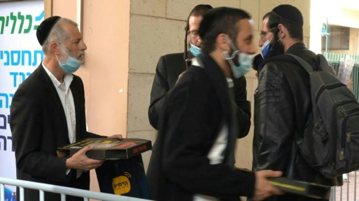 Israeli authorities distribute pizzas at a vaccination centre in the mainly ultra-Orthodox city of Bnei Brak