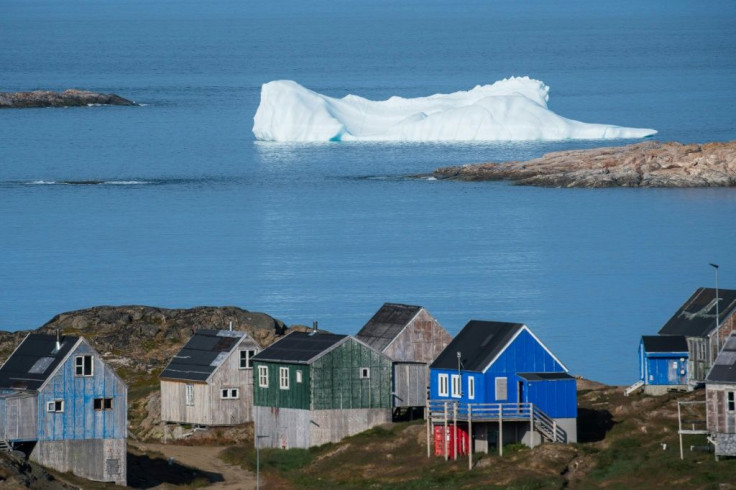 Icebergs float beyong the town of Kulusuk in Greenland. A mining project is reviving debate on the future of this immense Danish Arctic territory, already threatened by global warming but in search of resources for its eventual independence